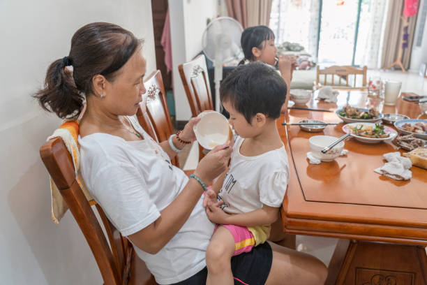 istock Grandma held her granddaughter and fed on her lap 1340733890