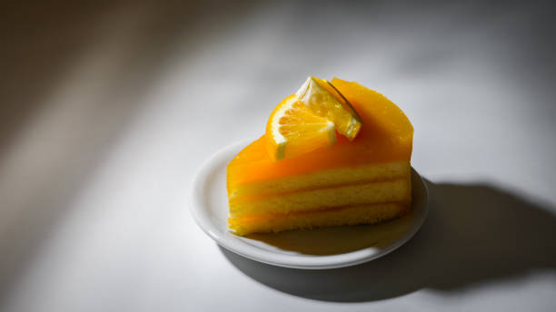 istock orange cake with orange topping on white plate 1340736578