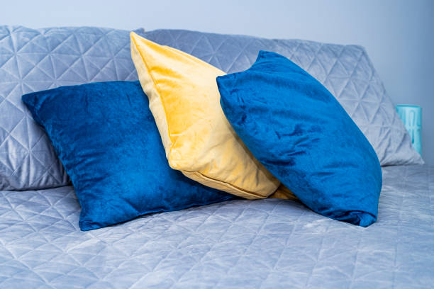 istock Gray bedspread and bright blue, yellow pillows on the bed. Scandinavian style. 1340736583