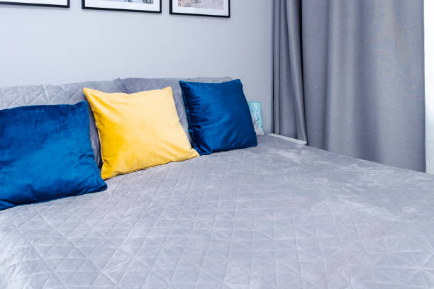 istock Gray bedspread and bright blue, yellow pillows on the bed. Scandinavian style. 1340736651
