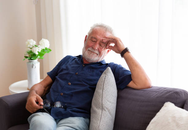 istock Senior man sleeping on sofa at home. Elderly man relaxing at home 1340736766