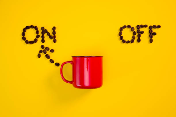 istock Cup of coffee on yellow background, switched on 1340738396