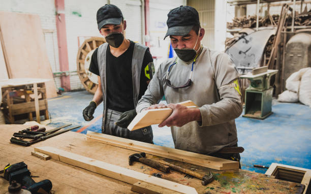 Young man and senior man working with wood stock photo