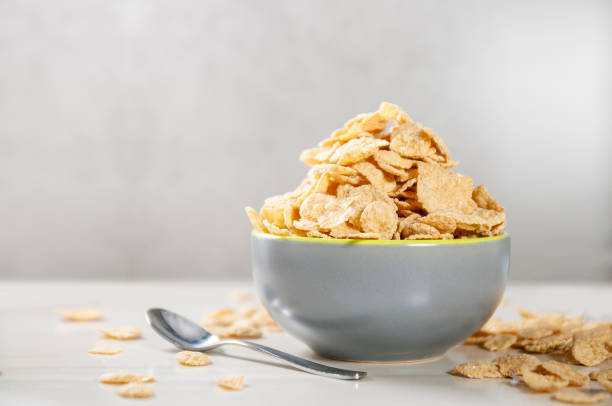 überdosierung corn flakes mit milch zum frühstück - cornflakes stock-fotos und bilder