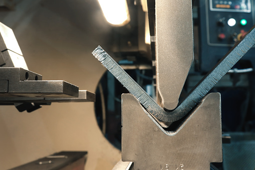 The process of metal bending on a CNC bending machine. Bending of metal using a v-shaped matrix and a punch.