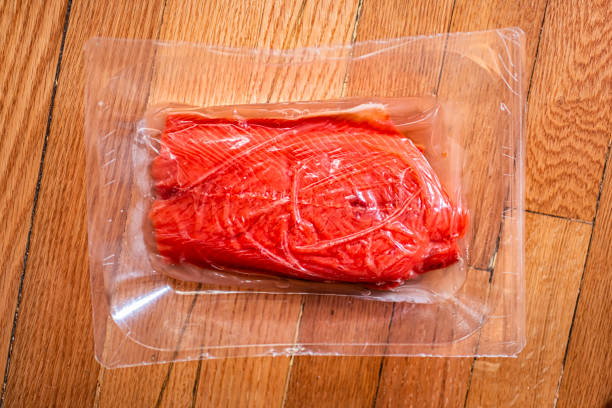 Raw sockeye salmon fillet with skin packaged storebought seafood fish vacuum packed sealed macro closeup showing texture on wooden floor or table Raw sockeye salmon fillet with skin packaged storebought seafood fish vacuum packed sealed macro closeup showing texture on wooden floor or table sockeye salmon filet stock pictures, royalty-free photos & images