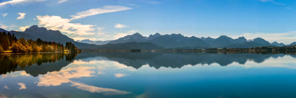 istock panoramic landscape in Bavaria at lake Forggensee mirroring alps mountains 1340753432