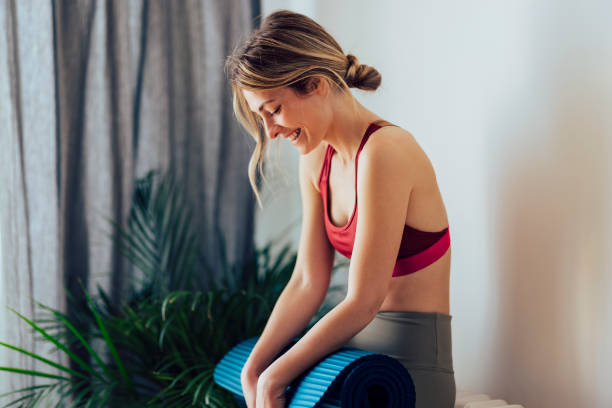istock Smiling Woman Holding Blue Exercise Mat 1340753639