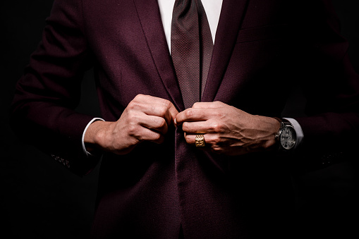 Man hands buttoning suit button