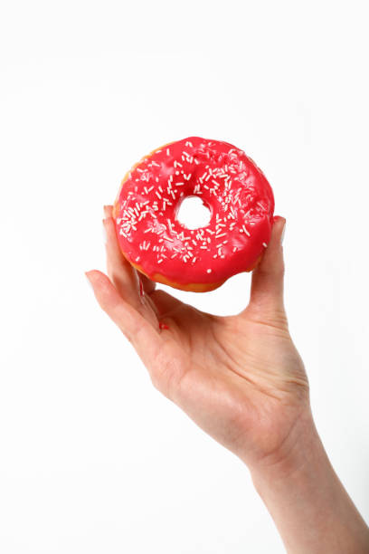 istock Woman hand holds red donut over white 1340756802