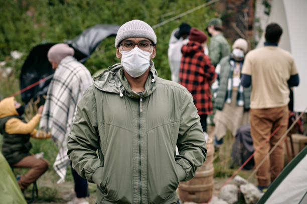 istock Man In Mask Against Crowd Of Migrants 1340756998