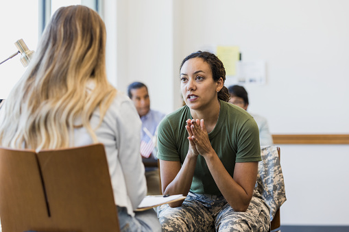 The unrecognizable female counselor listens to a stressed and anxious mid adult female soldier.