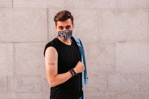 istock Portrait Of Vaccinated Man Showing His Arm 1340761084
