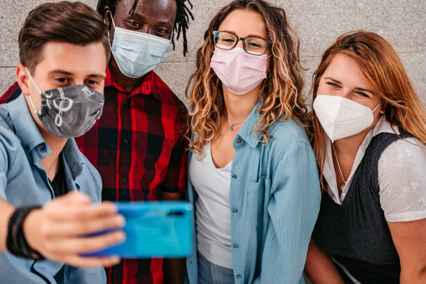 istock Multiracial friends with face masks making selfie 1340761913
