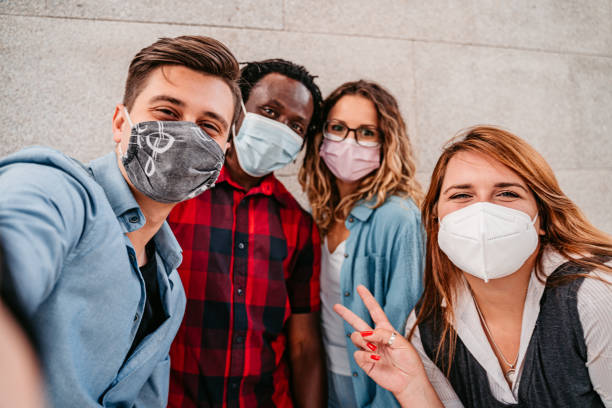istock Multiracial friends with face masks making selfie 1340761947