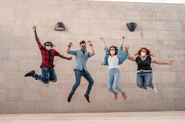 istock Happy friends jumping in front of a wall 1340762140