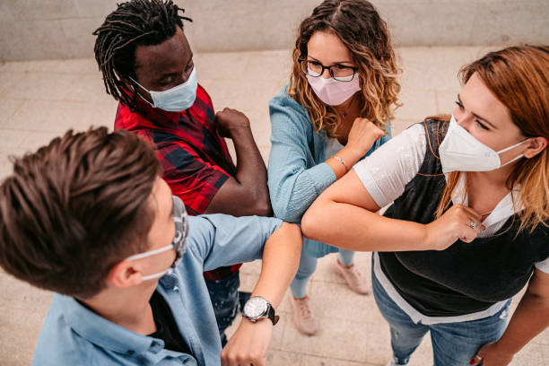 istock Four people greeting with elbow bump together 1340764213