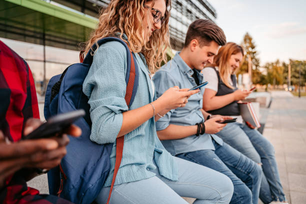 istock A Line Of College Students Using Mobile Phones 1340764611