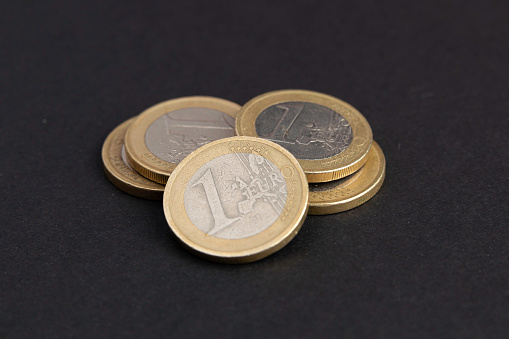 Euro coins piled up on black background