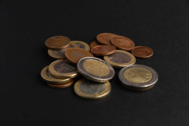 istock Euro coins piled up on black background 1340764735