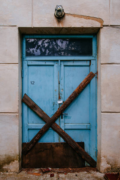 boarded up door wooden door of abandoned building - lock door horror gate imagens e fotografias de stock