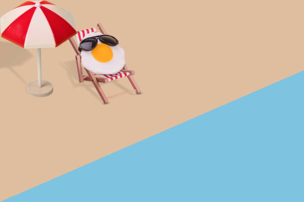 istock Creative funny composition made of sun umbrella, fried egg with sunglasses sitting on deck chair on the beach. 1340770226