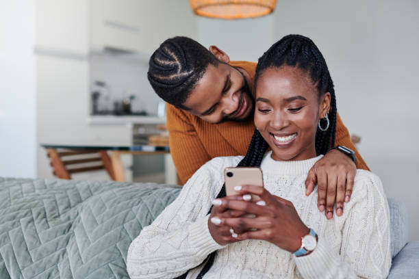 istock Shot of a young couple using a cellphone while relaxing together at home 1340770442