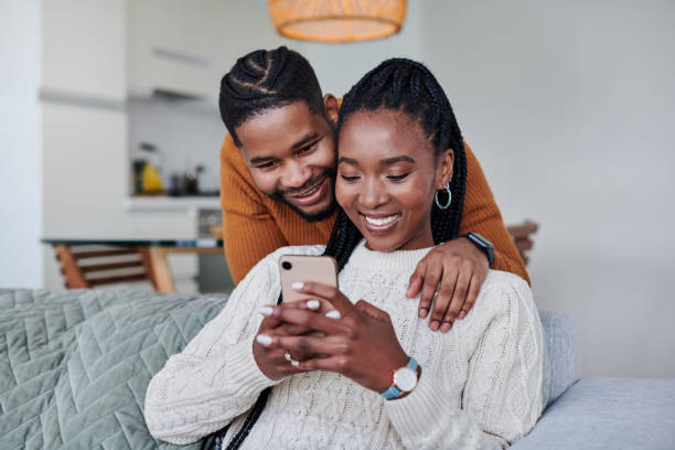 istock Shot of a young couple using a cellphone while relaxing together at home 1340770450