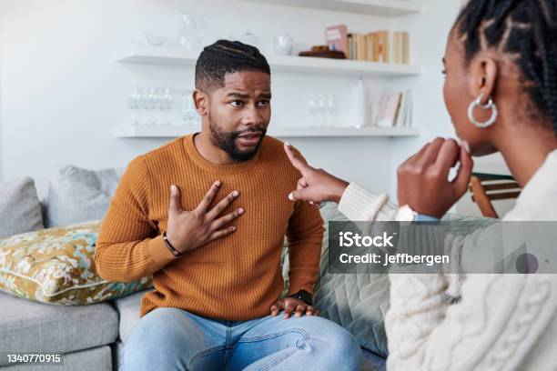 Shot Of A Young Couple Having An Argument At Home Stock Photo - Download Image Now - Arguing, Couple - Relationship, In The Dog House