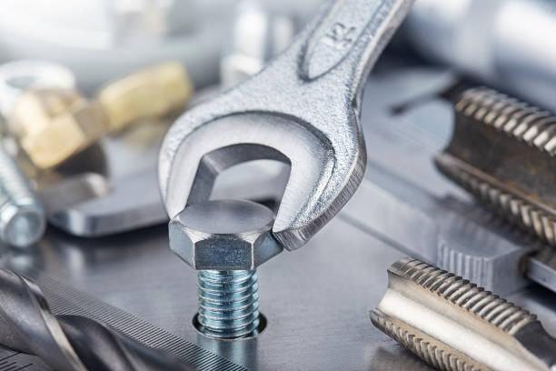 istock Wrench tightens bolt in steel billet. Spanner, bolt, screw and nuts. 1340771045