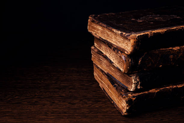 stack of old worn shabby jewish books in leather binding in the dark. closeup. selective focus. copy space. - low key imagens e fotografias de stock