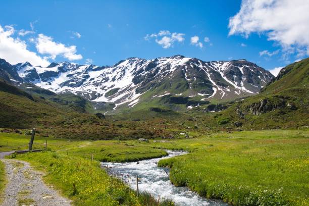 istock mountain river in the swiss alps at Davos, Duerrboden flows down with snow covered mountain in the background 1340774496