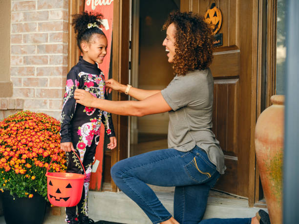 matka wysyła dziecko, aby poszło na sztuczkę lub leczenie w halloween - house halloween autumn candid zdjęcia i obrazy z banku zdjęć