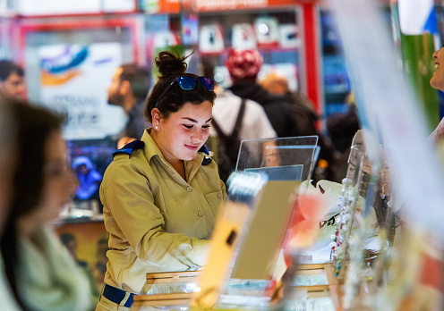 12-25-2014  Jerusalem , young woman (soldier) of the israeli army - chooses jewelry and smiles in a store in Jerusalem