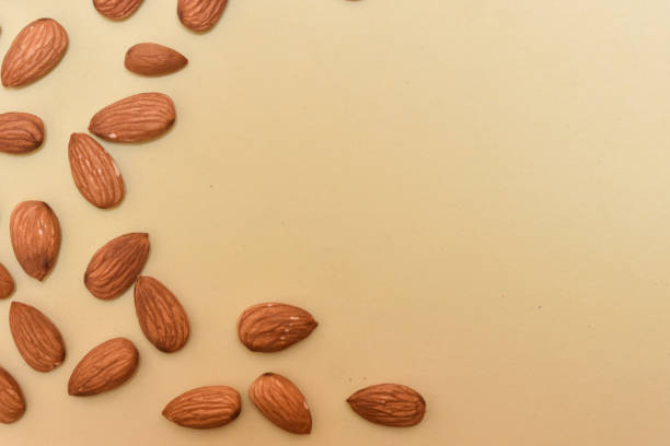 istock Almonds nuts against the yellow background with space for text 1340777767