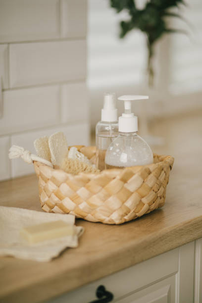 istock Kitchen interior with natural eco-friendly zero waste cleaning items: brushes, rugs, soap, spray and sponges in a wicker basket. 1340779775