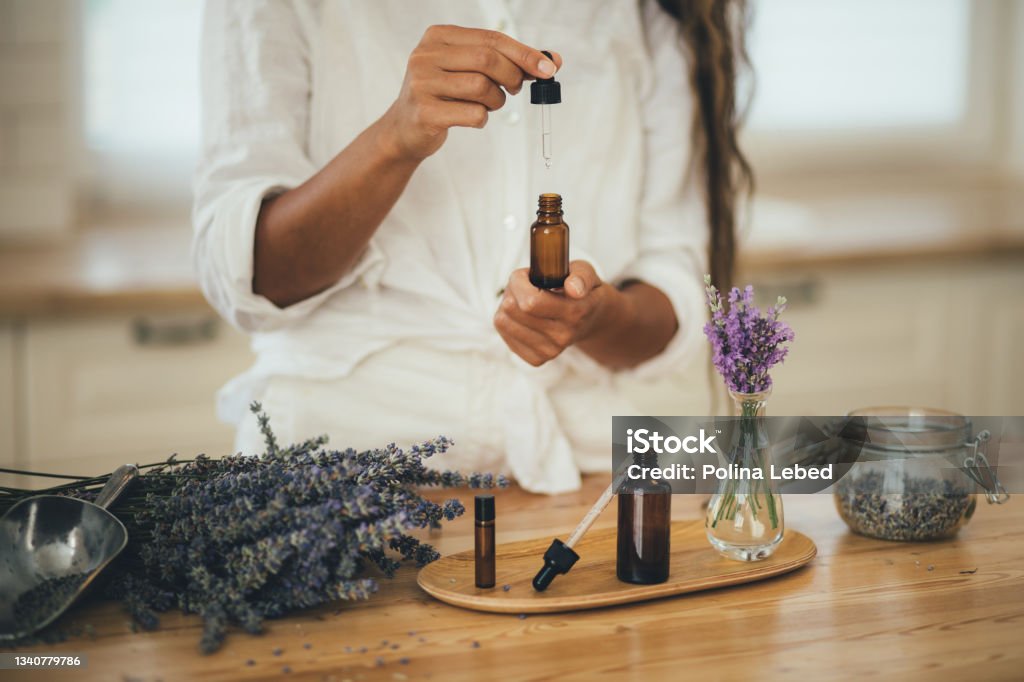 Young woman applying natural organic essential oil on hair and skin. Home spa and beauty rituals. Young woman applying natural organic essential oil on hair and skin. Home spa and beauty rituals. Skin care. Aromatherapy Stock Photo