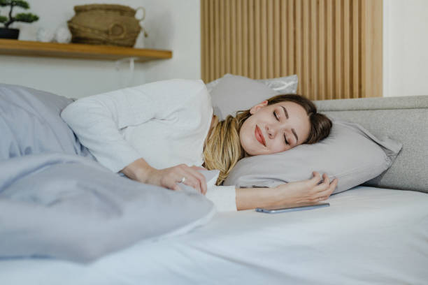 istock Young woman is sleeping in bed at home 1340787815