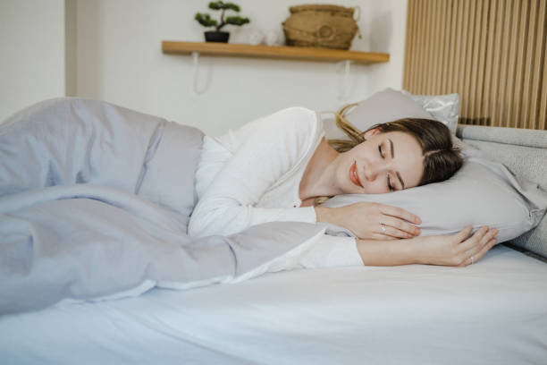 istock Young woman is sleeping in bed at home 1340787845