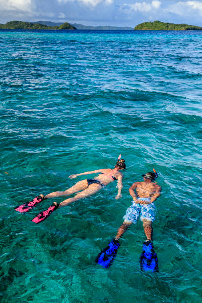 Young couple snorkeling on East China Sea, Philippines Young caucasian woman with her boyfriend snorkeling and watching turtles, East China Sea, Palawan Island, East China Sea, Philippines, Southeast Asia. cebu province stock pictures, royalty-free photos & images