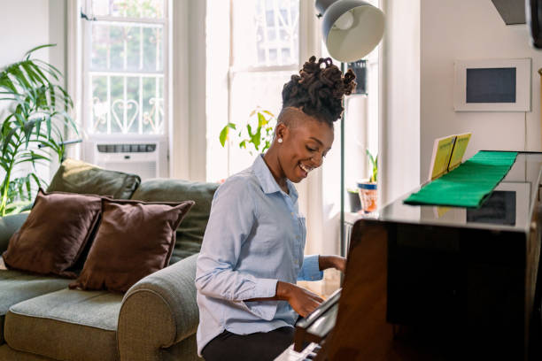 istock Black woman playing piano at home 1340801512