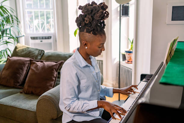 istock Black woman playing piano at home 1340801537