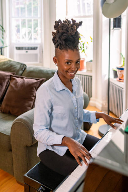 istock Black woman playing piano at home 1340801538