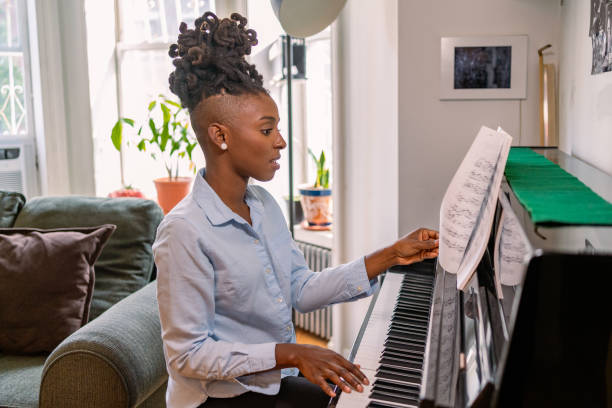istock Black woman playing piano at home 1340801539