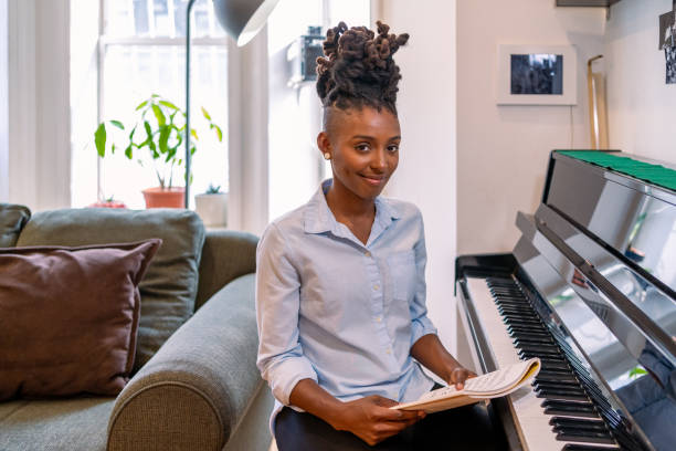 istock Black woman playing piano at home 1340801548