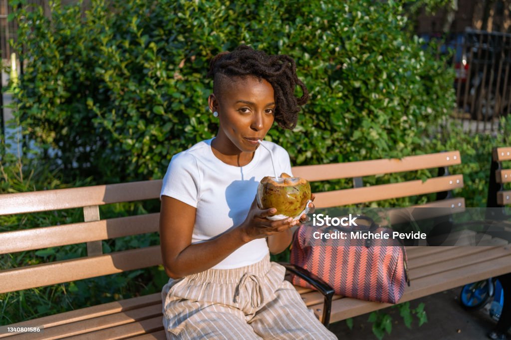 Black woman drinking a natural coconut water outdoors 30-34 Years Stock Photo