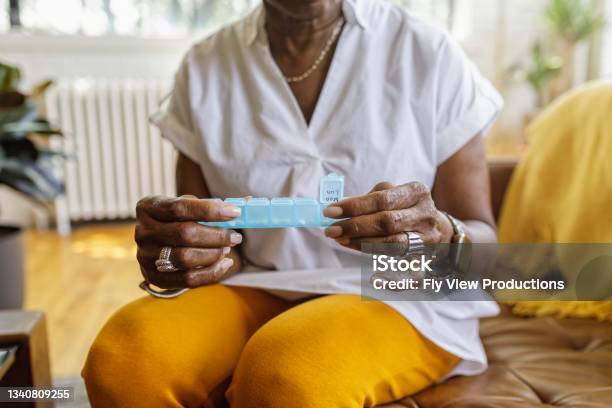 Woman Taking Daily Dosage Of Medicines Stock Photo - Download Image Now - Medicine, Senior Adult, Taking Medicine