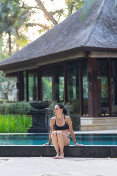 istock Mixed race woman sitting poolside 1340810871