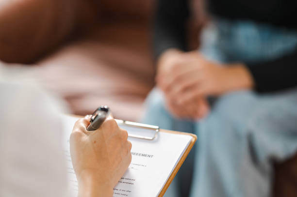 istock Psychologist making notes in medical history while understanding problems of a woman patient 1340812338
