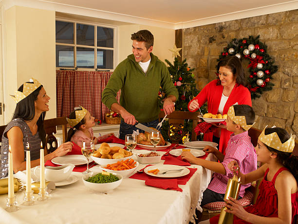Hispanic family serving Christmas dinner in dining room at home